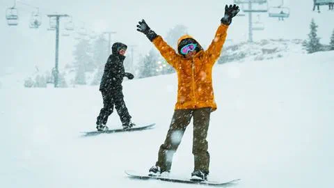 Two snowboarders on the slopes at Snow Valley on a snow day